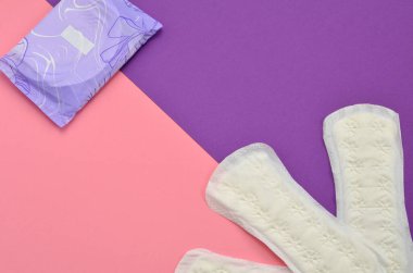 feminine hygiene products, pads on a pink-purple background, space for object