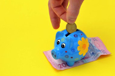 Ukraynalıların tasarruf konsepti, el domuz kumbarasına Hryvnia koyar