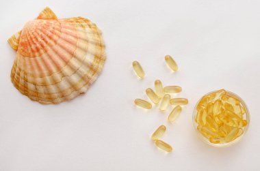 Beyaz zemin üzerinde omega 3 beslenme takviyesi ve deniz kabuğu