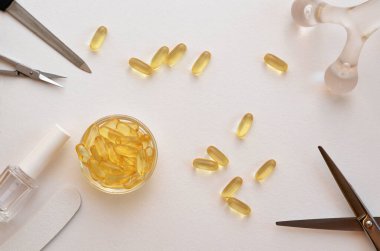 omega-3 kapsül ve tırnak, deri ve saç bakımı, makas, tırnak törpüsü ve oje aletleri