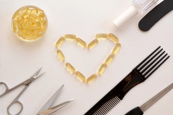 fish oil capsules and hair and nail care products, comb, scissors and nail file