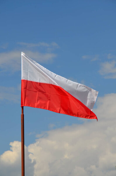 Polish flag waving against the blue sky