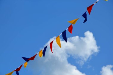 Mavi gökyüzü arka planında renkli küçük bayraklar