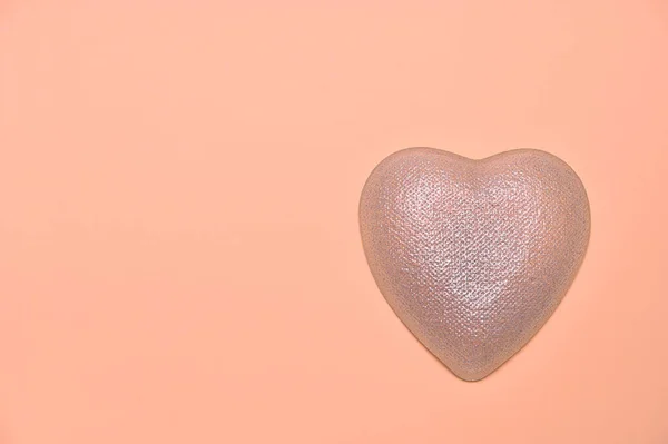 light heart on a peach background, copy space