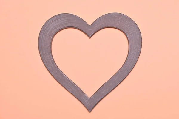 heart shaped frame on peach background close up