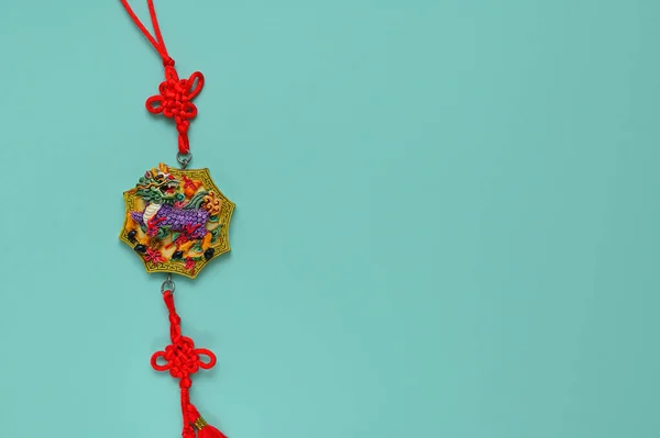 oriental decoration with a dragon and a red cord on a blue background, copy space