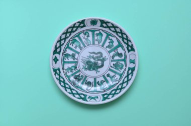 Yeşil arka planda Çin ejderhası resmi olan klasik bir plaka.