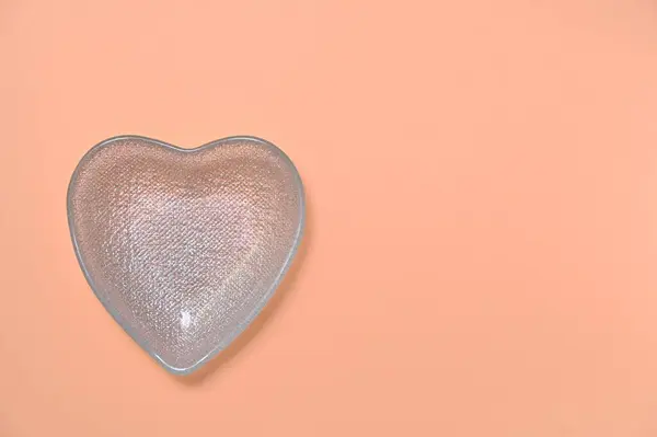 heart-shaped bowl on a peach background, copy space