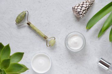 Masadaki cilt bakım ürünleri yeşim yüz masajı ve kremi