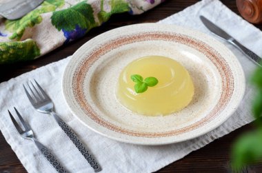 Ahşap bir masanın üzerinde bir porsiyon etli puding. Yakın plan.