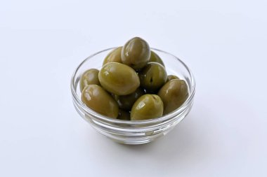 Beyaz arka planda yeşil zeytinli cam kase