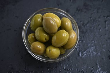 Siyah arka planda yeşil zeytinli kase