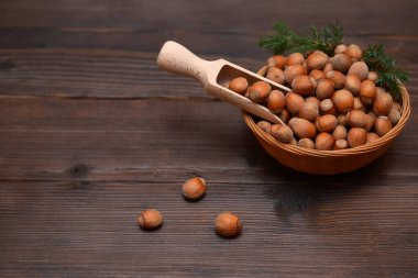 Tahta bir masada fındıklı bir sepetin içinde kepçeyle