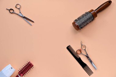 Şeftali arkaplanındaki kuaför aletleri, makas, tarak, saç fırçası, kopyalama alanı