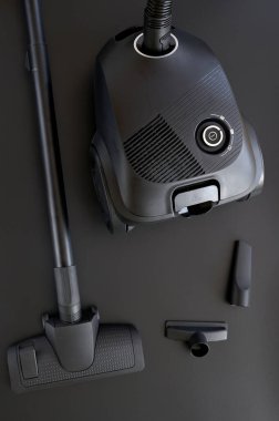 Siyah arkaplanda çeşitli eklentilere sahip elektrik süpürgesi