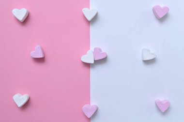 Beyaz pembe arka planda romantik bir resimde kalp şeklinde şekerlemeler.