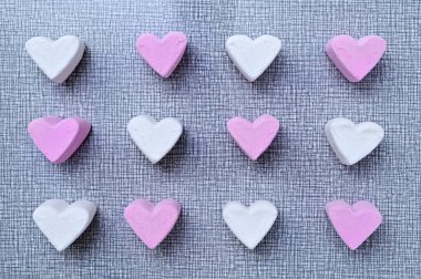 Gri bir zemin üzerinde kalp şeklinde beyaz pembe şekerlemeler yatıyordu.