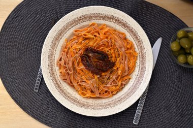 Renkli makarna sebze özleri ve kurutulmuş domatesler düzdü.