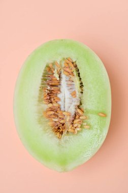 Pembe arka planda yeşil kavunun yarısı