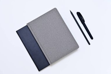 beyaz arkaplan üzerinde dizüstü bilgisayarlar ve yazma araçları yatıyordu