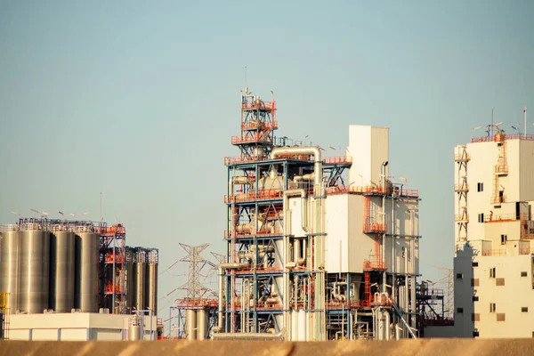 constructions, buildings, towers, chimneys, pipelines at a petrochemical plant in focus and out of focus, in selective focus, industrial view of the factory area.