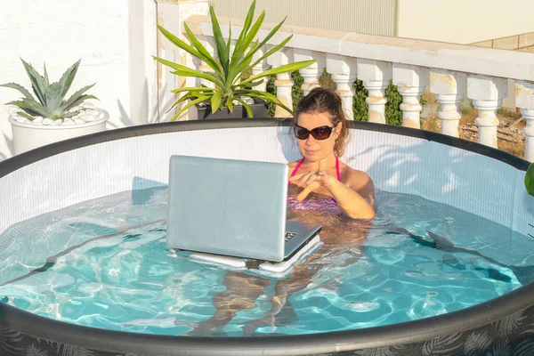 부풀어 오르는 선글라스를 소녀는 노트북 컴퓨터로 일한다 인터넷을 무더운 날씨에 — 스톡 사진