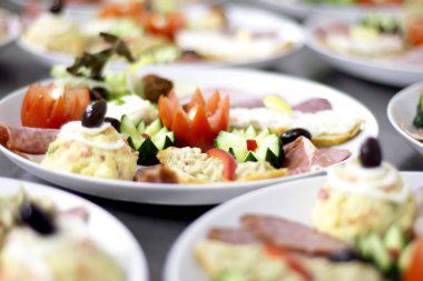 İştah açıcı yemek arkaplanı. Tabaklar güzel kesilmiş sebzelerle ve dekoratif bir şekilde bir restoranda kaplanmış, seçici bir odak noktası var. Sebzelerden çiçekler..