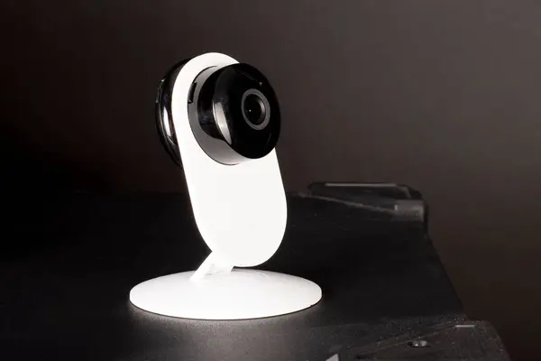 CCTV camera lens, security camera on a black background in a room on furniture, close-up, selective focus.