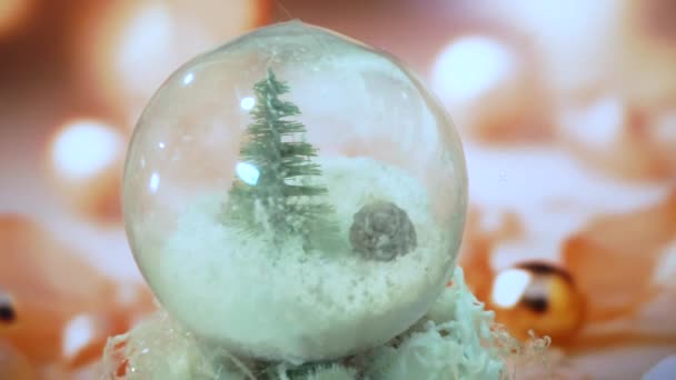 クリスマスツリー パインが入った透明なボールは ぼやけたライトやボールのお祝いの背景に軸を回転させます お土産や工芸品でクリスマスの家の装飾 — ストック動画