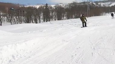 Tahtadaki erkek snowboardcu Goku sıçrama tahtasının üzerinden tehlikeli bir atlayış yapıyor.