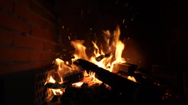 在火场的砖头背景下 夜间火焰和火花在燃烧的美丽视频 在黑暗的背景下 神奇的火舌和闪耀的火花在燃烧 — 图库视频影像