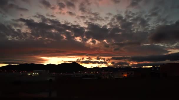 美しいランニング雲の魔法 驚異的なビデオタイムラプスは 夜の街の背景に対して日没の光の中で色と空を変化させます 時間と変化の過渡 — ストック動画