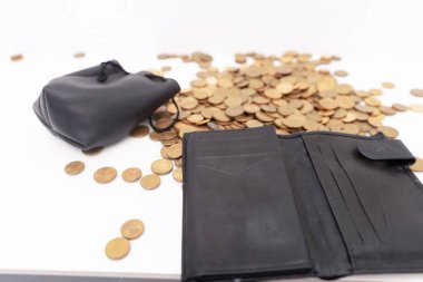 Bozuk para ve sentler bozuk para kutusundan bir yığın halinde ve masanın üzerine seçici bir şekilde deri bir domuz çantası dökülüyor. Kriz kavramı, son tasarruflar, düşük gelir, değer kaybı.