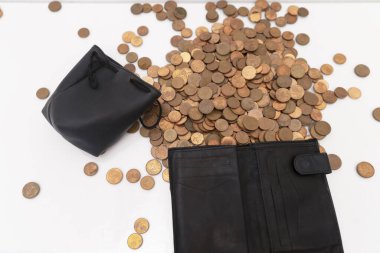 Bozuk para ve sentler bir bozuk para kutusundan ve masanın üzerine deri bir kumbara çantasından dökülüyor. Kriz kavramı, son tasarruflar, düşük gelir, değer kaybı.