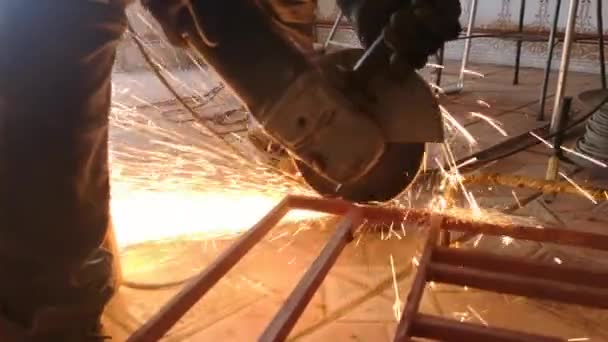 飛ぶ火花が付いているディスク機械が付いている金属の機械切断 労働者の手の円形工具が金属構造を切断する — ストック動画