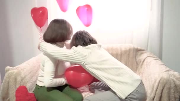 ベッドルームの心臓型風船の間で抱擁する恋人のカップル バレンタインデーのロマンチックな時間 ホリデーパーティー — ストック動画
