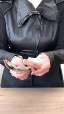 İş elbiseli bir kadının elleri bir yığın kağıt euro banknotunu sayar, zaman aşımına uğrar. Başarılı ticari işlemler, maliyet kontrolü, borç geri ödeme, borç alma, borç alma, yolsuzluk, rüşvet