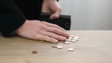 Yavaş çekim video arka planındaki adam avroyu ve sentleri cüzdanına koyuyor, eli masadan para atıyor. Para tasarruflarının denetlenmesi ve hesaplanması
