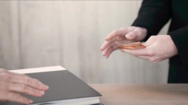 Elden ele para transferi ve içinde belgeler olan bir klasör. Avukat, avukat, muhasebeci hizmetleri için nakit ödeme. Rüşvet vermek ve kabul etmek