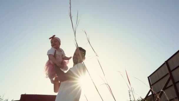 在夕阳西下的阳光下 爸爸带着他笑逐颜开的小女儿 带着欢乐家庭 父母和孩子们的浪漫视频 — 图库视频影像