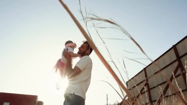 慢镜头 一个笑着的小孩和一个男人的父亲在夕阳西下的阳光下拥抱在一起 浪漫积极地度过一个幸福的家庭 信任和支持 — 图库视频影像