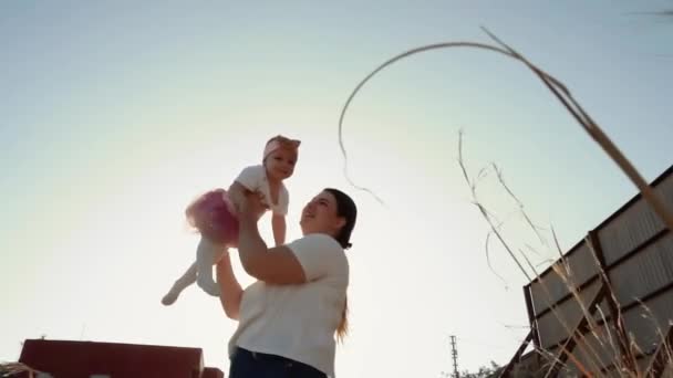 一位年轻的母亲在夕阳西下的阳光下 用一个快乐家庭 父母和孩子们的浪漫视频环绕着她笑逐颜开的小女儿 信任和支持 — 图库视频影像