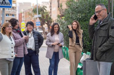 Bir grup insan aynı anda hem telefonda konuşuyor hem de izliyor. İletişim, bağlanma, bağlantı, arkadaşlar cep telefonuyla sohbet