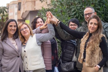 Birlik, takım çalışması, karşılıklı destek ve dostluğun sembolü olarak ellerini bir araya getiren bir grup insan. Eşitlik, işbirliği ve ortaklık sembolü