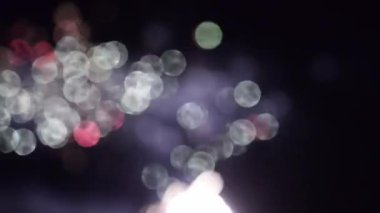 Güzel, hareketli, renkli bir flaşın ışıltılı arka planı ve bir partide kıvılcımlar saçan havai fişekler. Noel 'i, düğünleri, yıldönümlerini kutlarız..