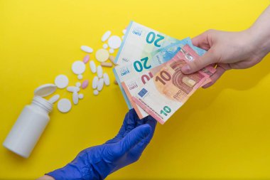 Bir adam eczacılara eczacının arka planında tıbbi eldiven veren bir adama euro banknotları veriyor. Uyuşturucu almak. reçete, tedavi için ödeme