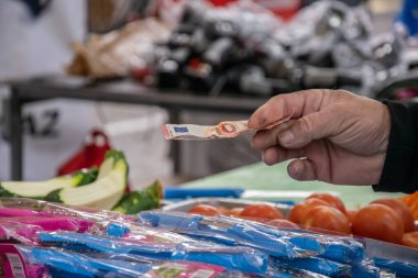 Fakir bir adam, bir marketten mal almak için on avroluk banknot tutuyor. nakit ödeme, satın alma, fiyat artışı, alıcı, ödeme, perakende