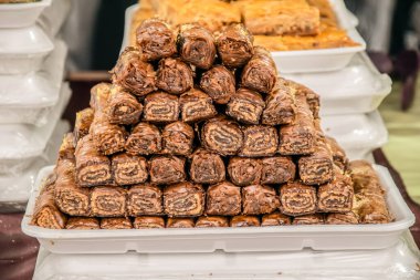 Tatlı hamur işleriyle dolu bir tabak, yiyecek pazarında sergilenen çikolata dolu dürümler. yüksek kalorili ürün