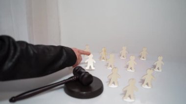 Yargıç bir grup insanın arasından suçlu birini seçer ve tokmağa vurarak bir karar verir. Kanun ve disiplin. İnsanlığın kontrolü ve manipülasyonu. Hukukun gücünün sınırlandırılması. Komplo teorileri