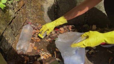 Rio de Janeiro 'da ormanın ortasında plastik şişe ve diğer döküntüleri toplayan bir gönüllüyü yakından çek. Brezilya 'daki Atlantik Ormanı. Dünya Günü konsepti.
